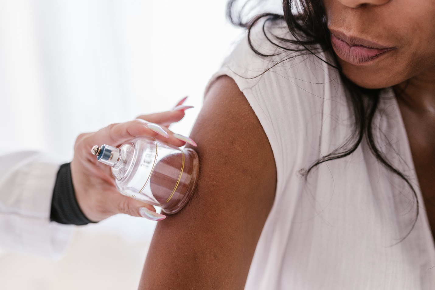 A chiropractor using cup therapy on a woman