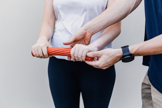 A chiropractor making a woman perform exercises