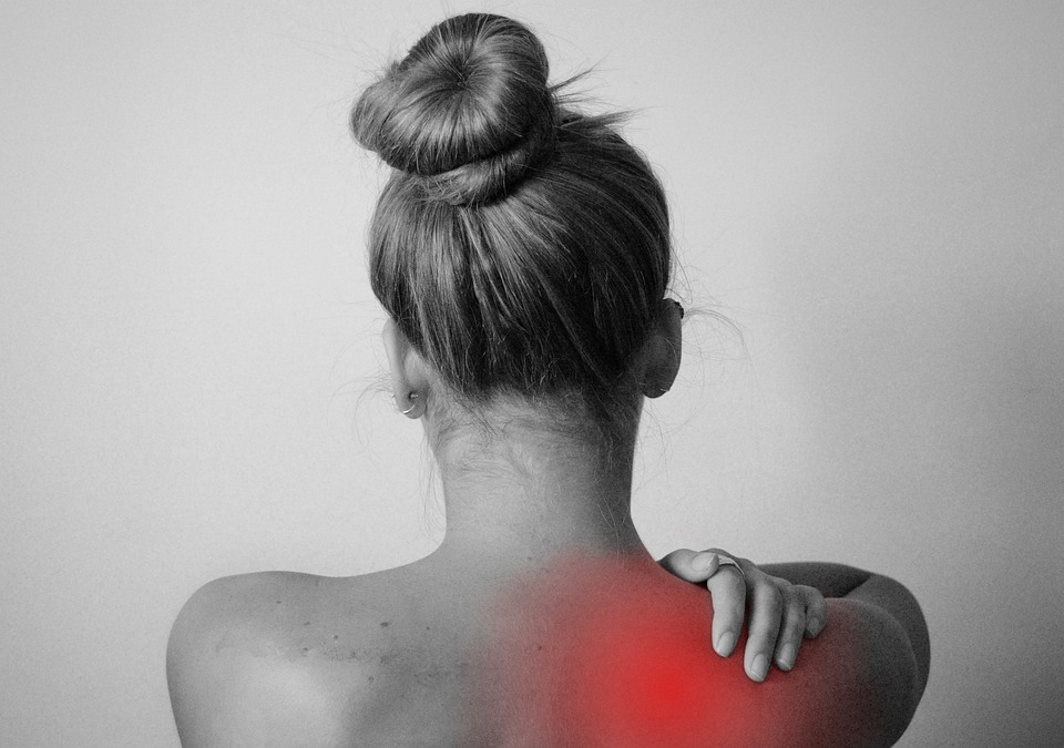 A female experiencing back and shoulder pain.  