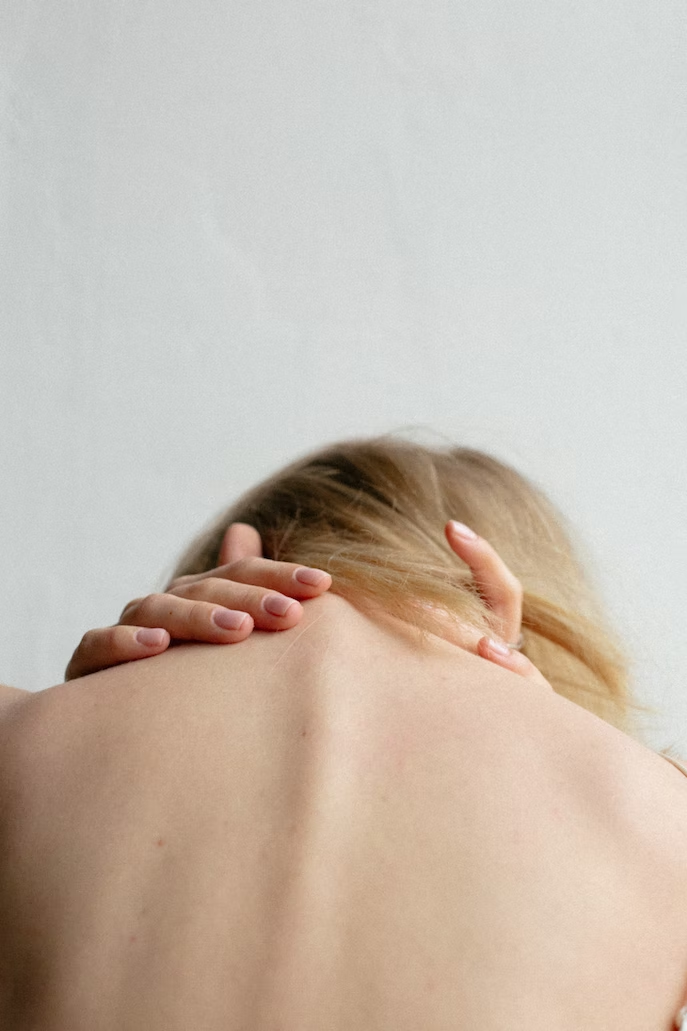 A Woman touching her bent back