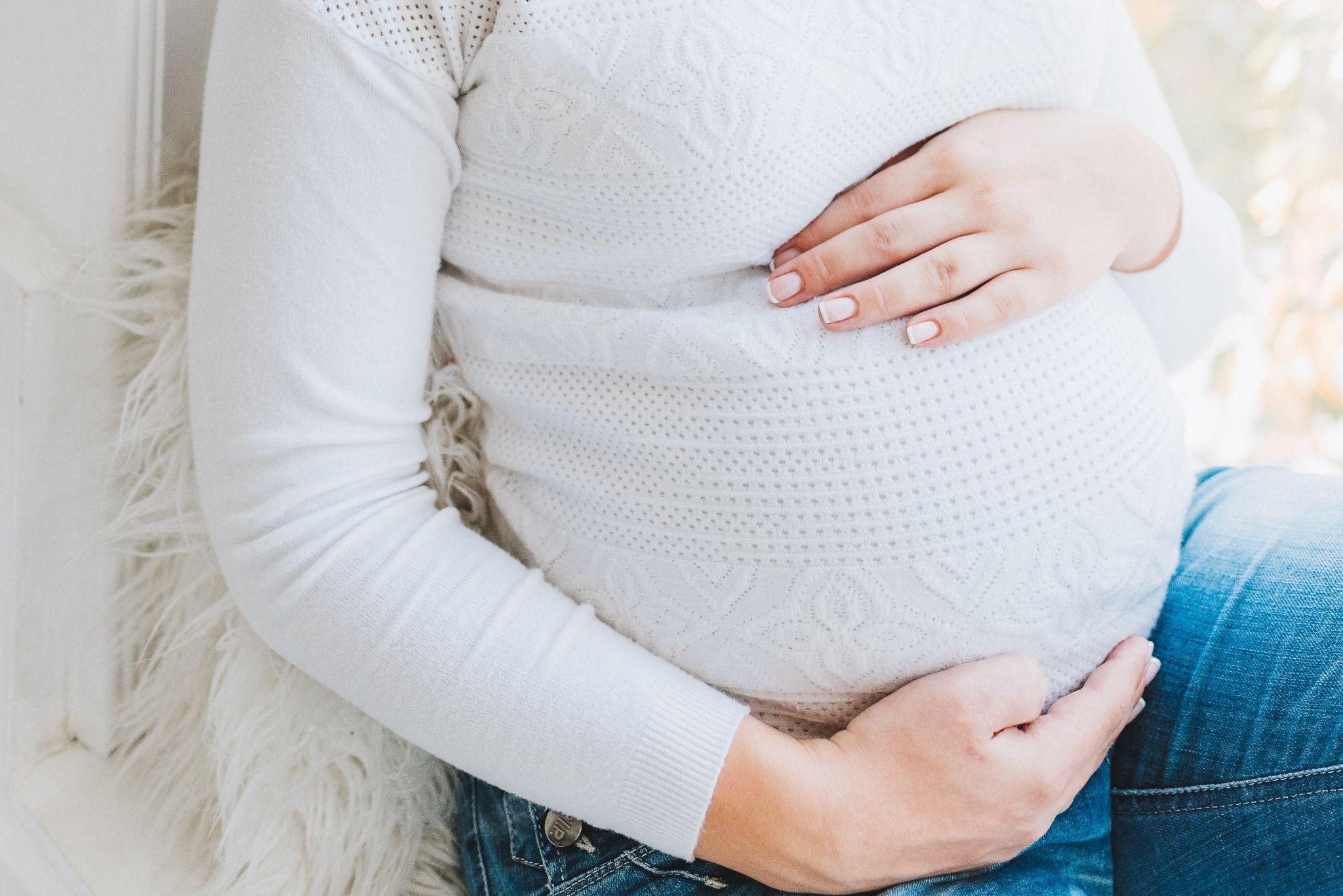 Image of the torso of a seated pregnant person