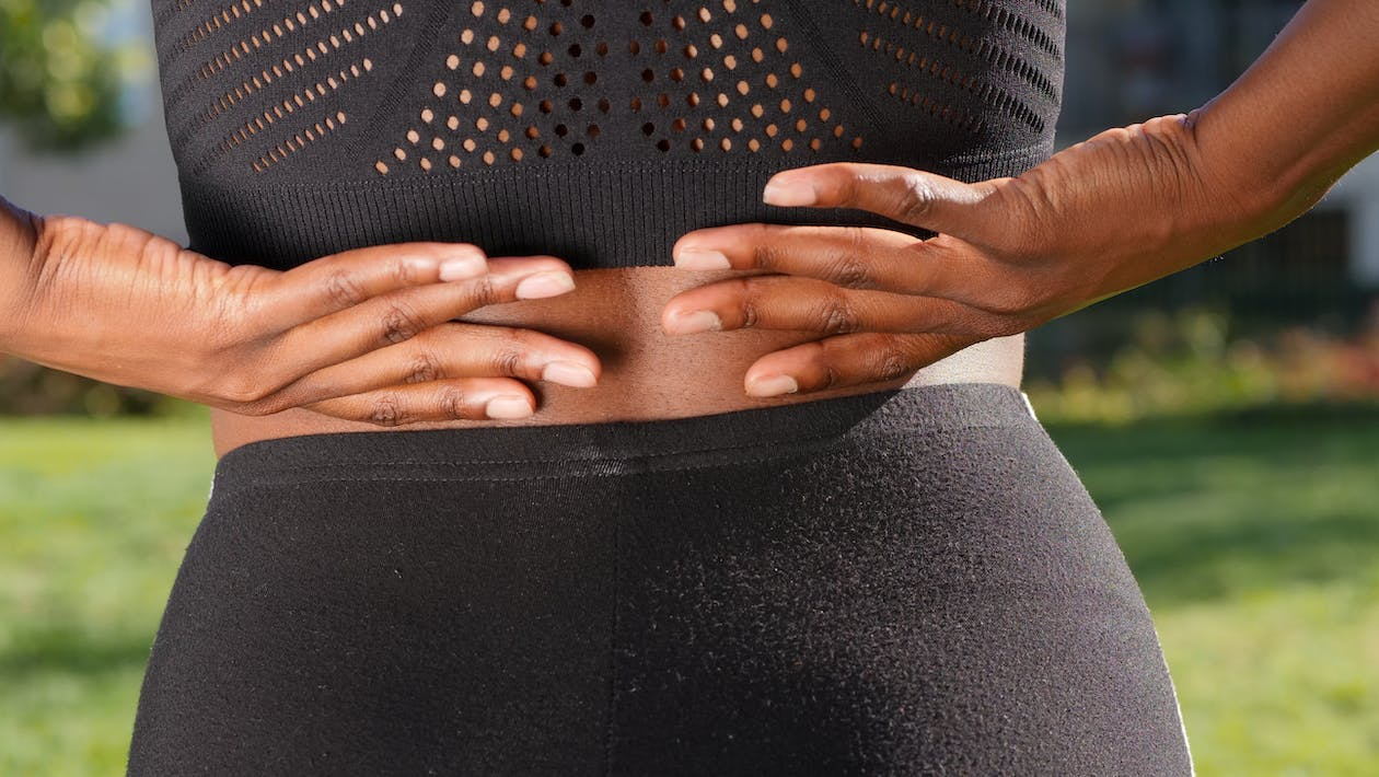 A close-up of a woman experiencing lower back pain