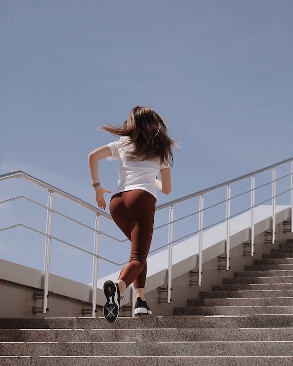 A woman running effortlessly on stairs after consulting a chiropractor 