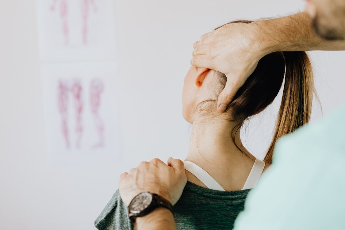 A chiropractic treating a woman having neck pain