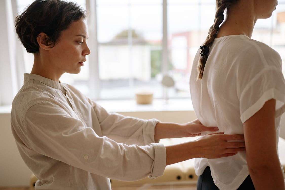  A chiropractor working on a woman having lower back pain