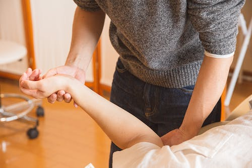 An image of a chiropractor massaging a patient’s hand 