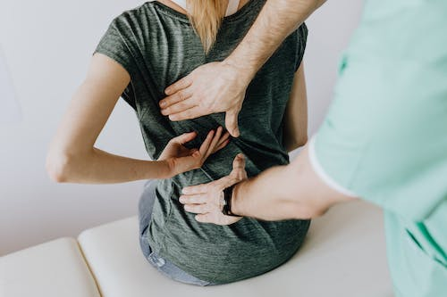 An image of a doctor examining a woman’s back