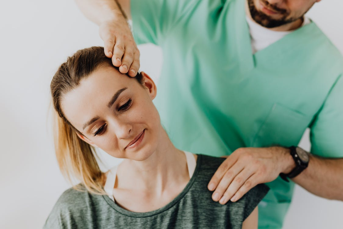 A professional chiropractor treating a female patient's neck