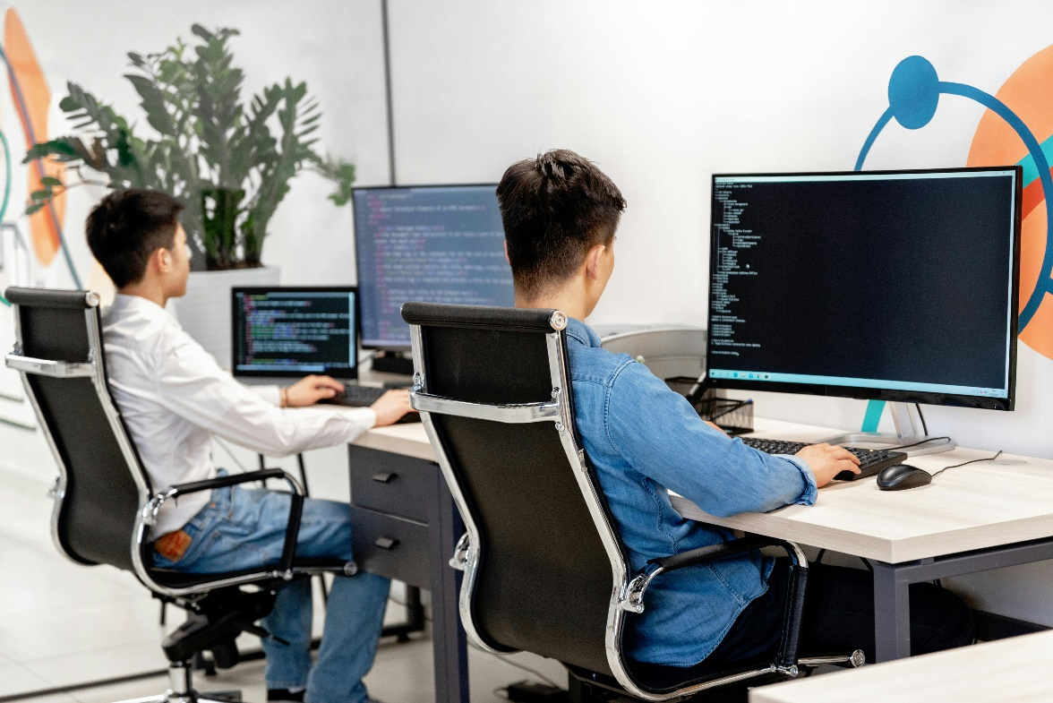 People sitting on their workstations, using computers.