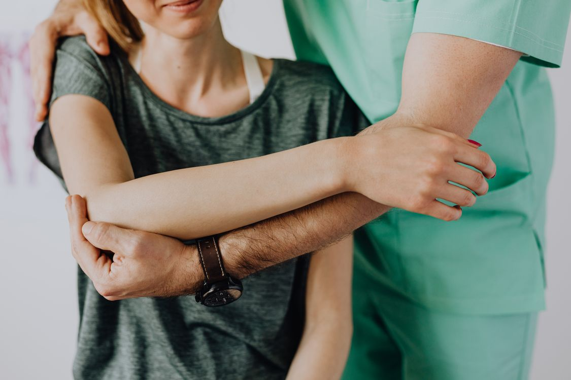 A picture shows a chiropractor stretching a patient who is experiencing joint pain